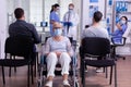 Worried disabled old woman sitting in wheelchair in hospital looking at camera Royalty Free Stock Photo