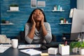 Worried displeased african student suffering headache migraine sitting at desk table