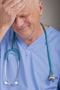 Worried doctor / nurse with head in hand. Royalty Free Stock Photo