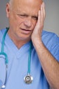 Worried doctor / nurse with head in hand. Royalty Free Stock Photo