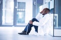 Worried doctor sitting on floor Royalty Free Stock Photo