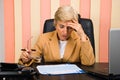 Worried elderly woman working in office Royalty Free Stock Photo