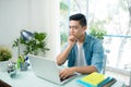 Worried entrepreneur young man working at desk on laptop looking Royalty Free Stock Photo