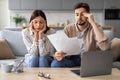 Worried european couple with paperwork and laptop Royalty Free Stock Photo