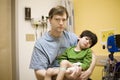 Worried father holding his sick son at hospital