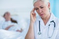 Worried female doctor looking away while her patient resting