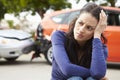 Worried Female Driver Sitting By Car After Traffic Accident