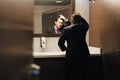 Worried Hispanic Business Man Looking At Hairline In Office Restrooms