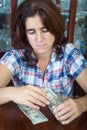 Worried hispanic woman counting her savings at home Royalty Free Stock Photo