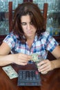 Worried hispanic woman counting her savings at home Royalty Free Stock Photo