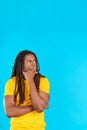 Worried latin man with dreadlocks looking up with pensive expression Royalty Free Stock Photo