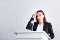 worried lecturer, suffering from glossophobia, holding napkin near forehead while standing on podium tribune. Royalty Free Stock Photo