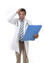 Worried male medicine doctor with stethoscope in medical gown reading clipboard diagnostic stressed Royalty Free Stock Photo