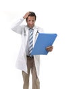 Worried male medicine doctor with stethoscope in medical gown reading clipboard diagnostic stressed Royalty Free Stock Photo