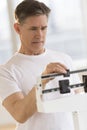 Worried Man Checking His Weight On Balance Scale Royalty Free Stock Photo