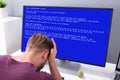 Worried Man At Computer With System Failure On The Screen