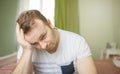 Worried man in his bedroom thinking about problems