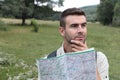 Worried man lost hiking confused looking at map