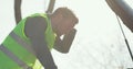 Worried man in a safety vest holding his head by hand standing near his broken car with raised hood on the road. Concept Royalty Free Stock Photo