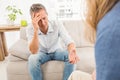 Worried man sitting on couch and talking to therapist Royalty Free Stock Photo