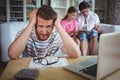 Worried man sitting at table with bills and laptop Royalty Free Stock Photo