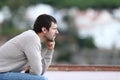 Worried man thinking looking away sitting on a bench Royalty Free Stock Photo