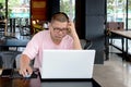 worried man using a laptop computer and looking at the screen., Royalty Free Stock Photo