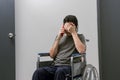 Worried man in wheelchair talking on cell phone