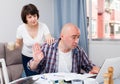 Worried man working at laptop and financial documents, woman helping Royalty Free Stock Photo