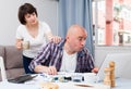 Worried man working at laptop and financial documents, woman helping Royalty Free Stock Photo