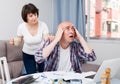 Worried man working at laptop and financial documents, woman helping Royalty Free Stock Photo