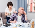 Worried man working at laptop and financial documents, woman helping Royalty Free Stock Photo