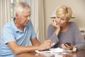 Worried Mature Couple Checking Finances And Going Through Bills Together Royalty Free Stock Photo