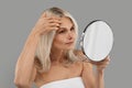 Worried Mature Woman Looking At Mirror On Wrinkles At Her Face Royalty Free Stock Photo