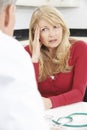 Worried Mature Woman Meeting With Doctor In Surgery Royalty Free Stock Photo