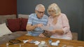 Senior couple looking at medicine prescription, pills, tablets at home. Coronavirus lockdown