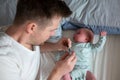 Worried oung father looking on thermometer holding his newborn baby in hands. Royalty Free Stock Photo