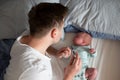 Worried oung father looking on thermometer holding his newborn baby in hands. Royalty Free Stock Photo