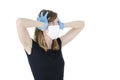 Worried person with virus protection surgical face mask and gloves holding her head in panic, looking side.