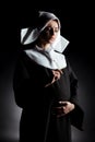 Worried pregnant nun holding cross and touching belly Royalty Free Stock Photo