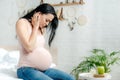 Worried pregnant woman having pain and looking at belly Royalty Free Stock Photo