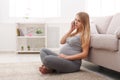 Worried pregnant woman talking on phone copy space