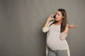 Worried pregnant woman talking on phone copy space