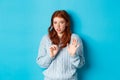 Worried redhead girl refusing or declining an offer, shaking hands and looking anxiously at camera, rejecting something Royalty Free Stock Photo