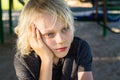 Worried, sad child alone in school playground