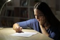 Worried sad woman signs contract at night at home Royalty Free Stock Photo