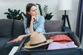 Worried sad young female having trouble packing suitcase bag, sitting on sofa at home or hotel, not ready, woman forgot things Royalty Free Stock Photo