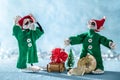 Worried Santas Helper Elf With Head in Hands Standing Next to Another Elf That Broke a Christmas Bauble.North Pole Christmas Scene Royalty Free Stock Photo