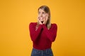 Worried scared young blonde woman girl in casual clothes posing isolated on yellow orange wall background in studio Royalty Free Stock Photo