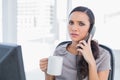 Worried secretary answering phone Royalty Free Stock Photo